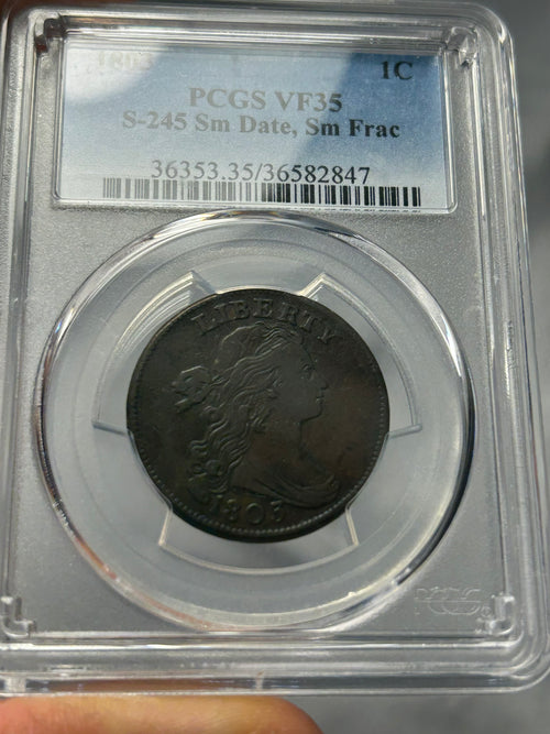 Coin in a protective case with grading label, held by a hand