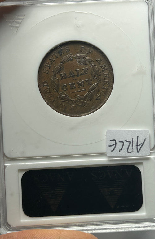 Vintage half cent coin in a protective case with a label